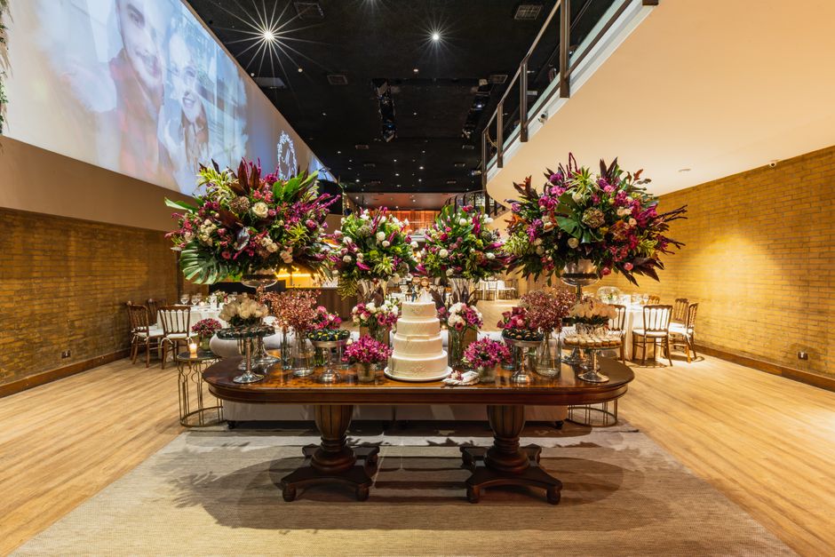 Luxurious wedding cake display with vibrant floral arrangements in an elegant setting.